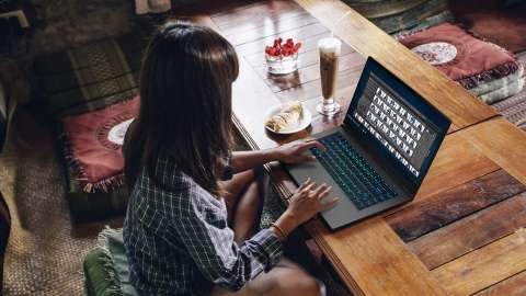 Perempuan bekerja dengan foto di laptopnya